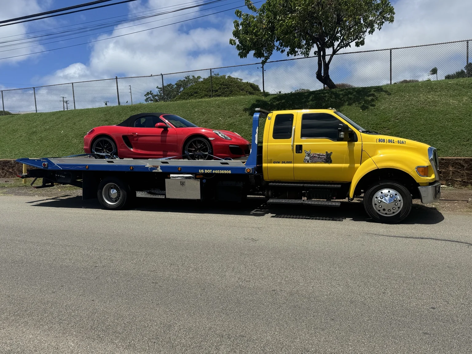 Red Porsche secured on an APM Towing flatbed truck