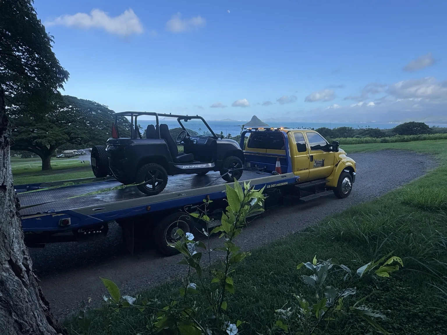 APM Towing flatbed transporting an off-road vehicle with Hawaii scenery