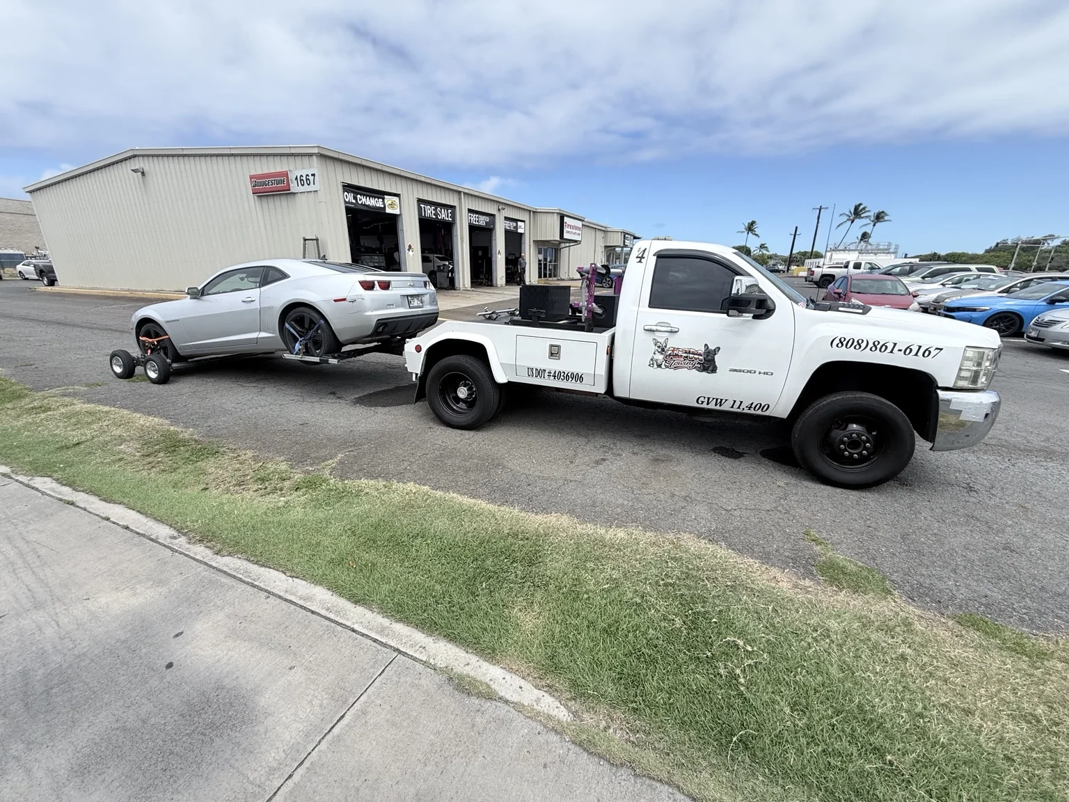 APM Towing wheel-lift truck transporting a Camaro